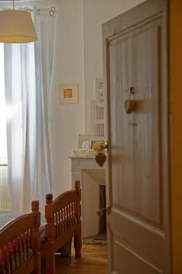 a bedroom with a bed and a door with a fireplace at Maison Rives - Village du Livre de Montolieu in Montolieu