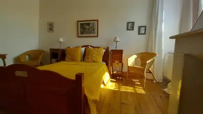 a bedroom with a bed with a yellow blanket at Maison Rives - Village du Livre de Montolieu in Montolieu