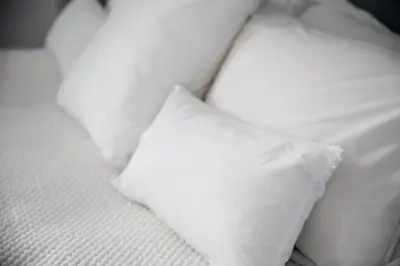 a white bed with two white pillows on it at Chateau de Thuries in Revel