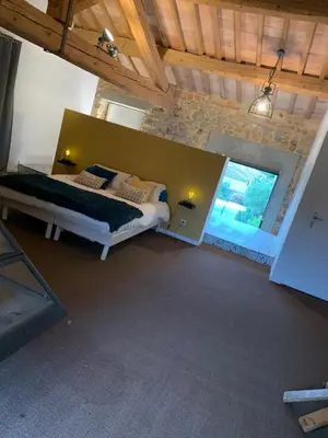 a bedroom with a large bed in a room at CHAMBRE D’HÔTES NATURE ET SAVEURS in Boutenac