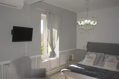a bedroom with a bed and a chair and a television at CHAMBRE D’HÔTES NATURE ET SAVEURS in Boutenac