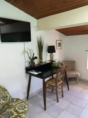 a room with a table with a chair and a tv at atmosphere in Poilhès