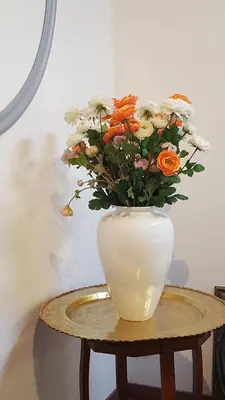 a white vase filled with flowers sitting on a table at atmosphere in Poilhès
