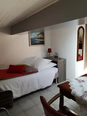 a bedroom with a large white bed and a table at atmosphere in Poilhès