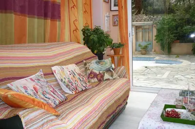 a bed sitting in a room with a view of a pool at LES BRUYERES chambre d'hôte de charme Calme assuré in Loupia