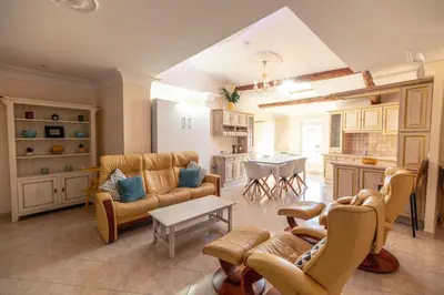 a living room with couches and a table and a kitchen at Appartement du Couvent in Narbonne