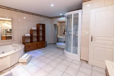 a bathroom with a tub and a shower and a sink at Appartement du Couvent in Narbonne