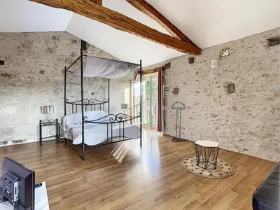 a bedroom with a bed in a brick wall at GITES STE CATHERINE in Teyssode