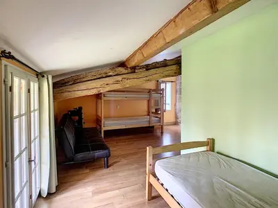 a bedroom with a bed and a green wall at GITES STE CATHERINE in Teyssode