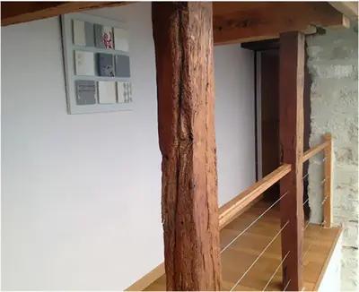 a wooden beam in a room with a staircase at GITES STE CATHERINE in Teyssode