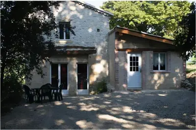 a building with a bench in front of it at GITES STE CATHERINE in Teyssode
