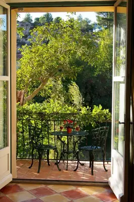 a patio with a table and chairs on a balcony at The Balcony Gîte - Riverside Lagrasse in Lagrasse
