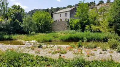 an old house in the middle of a river at The Balcony Gîte - Riverside Lagrasse in Lagrasse