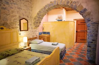 a bedroom with two beds in a room with an arch at The Balcony Gîte - Riverside Lagrasse in Lagrasse