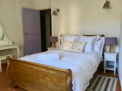 a bedroom with a large bed with white sheets and pillows at La maison Vigne Vierge in Lagrasse
