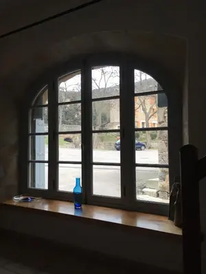 a window with a blue vase sitting on a wooden window sill at La maison Vigne Vierge in Lagrasse
