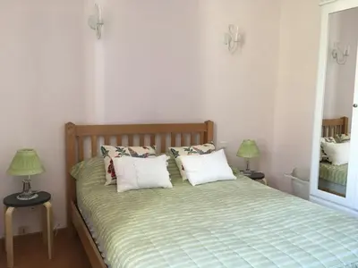 a bedroom with a bed with two lamps and a mirror at La maison Vigne Vierge in Lagrasse