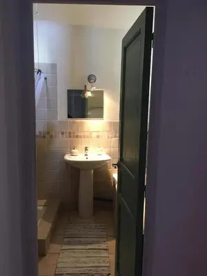 a bathroom with a sink and a toilet and a mirror at La maison Vigne Vierge in Lagrasse