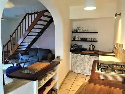 a living room with a blue couch and a staircase at La maison Vigne Vierge in Lagrasse