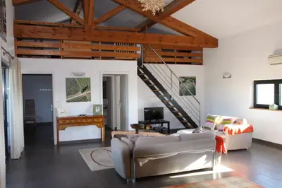 a living room with a couch and a staircase at Domaine de Cazaban in Villegailhenc