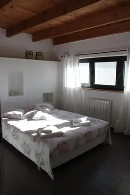 a bedroom with a large bed with a window at Domaine de Cazaban in Villegailhenc