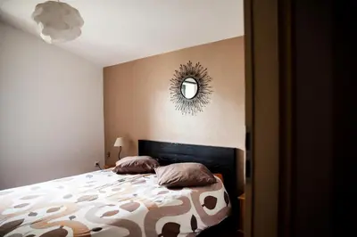 a bedroom with a bed and a mirror on the wall at Domaine de Cazaban in Villegailhenc
