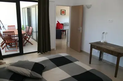 a bedroom with a bed and a table and a dining room at Domaine de Cazaban in Villegailhenc