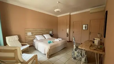 a bedroom with a bed and a desk and a chair at Château La Sabine in Saint-Laurent-de-la-Cabrerisse