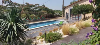 a swimming pool in the middle of a garden at Château La Sabine in Saint-Laurent-de-la-Cabrerisse