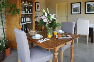a wooden table with a vase of flowers on it at Château La Sabine in Saint-Laurent-de-la-Cabrerisse