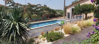 a swimming pool in the middle of a garden at Château La Sabine in Saint-Laurent-de-la-Cabrerisse