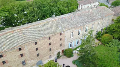 an overhead view of a large brick building with trees at Château de Vallègue in Vallègue