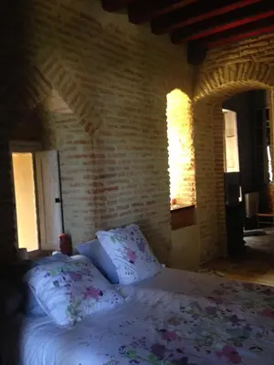 a bedroom with a bed with white sheets and pillows at Château de Vallègue in Vallègue