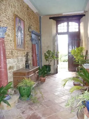 a room with potted plants and a brick wall at Château de Vallègue in Vallègue