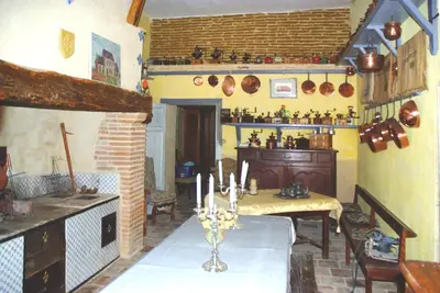 a kitchen with a table and a stove in a room at Château de Vallègue in Vallègue