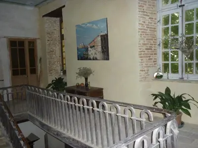 a staircase in a building with a painting on the wall at Château de Vallègue in Vallègue