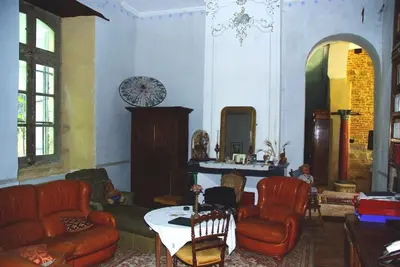 a living room with red chairs and a table at Château de Vallègue in Vallègue