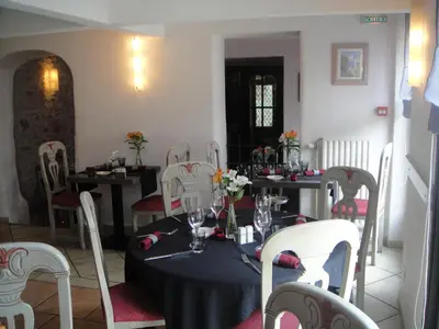a dining room with tables and chairs with flowers on them at Auberge des Lices in Carcassonne
