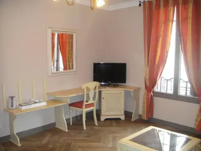 a room with a desk with a television and a desk with a chair at Auberge des Lices in Carcassonne