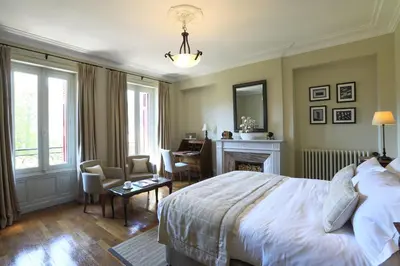 a bedroom with a bed and a desk and a fireplace at La Villa de Mazamet in Mazamet