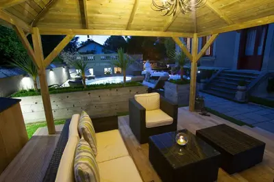 a wooden pavilion with a couch and a table at La Villa de Mazamet in Mazamet