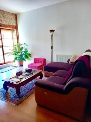 a bed in a room with a stone wall at Chambres d'hôtes Sous L'Olivier in Trausse