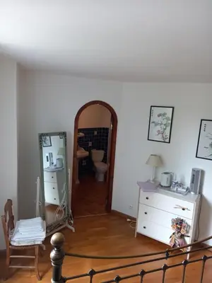 a room with a mirror and a chair and a dresser at Chambres d'hôtes Sous L'Olivier in Trausse