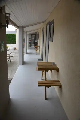 a row of benches sitting on the side of a building at Hotel Motel Limoux in Limoux
