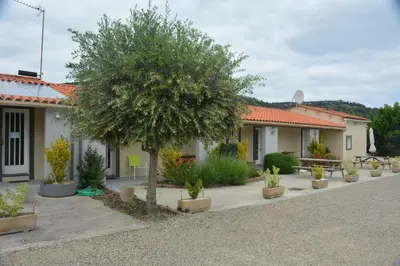 a house with a tree in a courtyard at Hotel Motel Limoux in Limoux