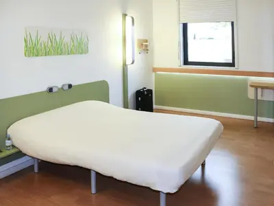a small room with a bunk bed and a mirror at ibis budget Castelnaudary - A61 in Castelnaudary