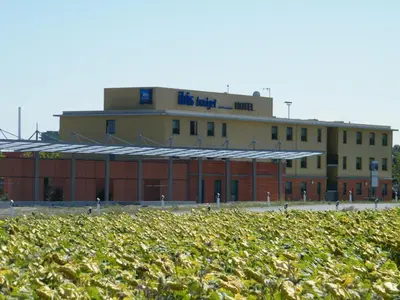 a row of tables and chairs next to a fence at ibis budget Castelnaudary - A61 in Castelnaudary