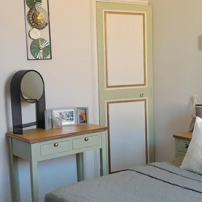 a bedroom with a bed and a table with a mirror at Entre Bastide et Cité et son rooftop in Carcassonne