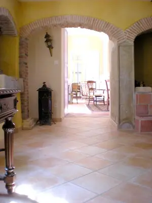 a room with an archway with a fireplace and a table at Manoir enchanteur à Cailhau avec piscine privée sécurisée in Cailhau