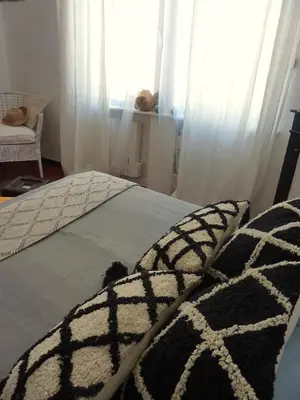 a bed with a black and white blanket and a window at La Maison narbonnaise in Narbonne